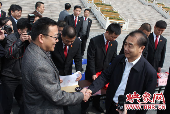 在新密市法院，省高院院長張立勇為拍得轎車的陳先生發(fā)放車鑰匙。