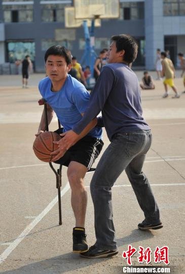 圖為拄著拐杖的瞿詩濤和同學(xué)搶球。劉占昆攝