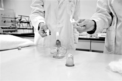 實(shí)驗(yàn)人員操作的燃燒檢測法中，真蠶絲離開火焰就熄滅(左)。