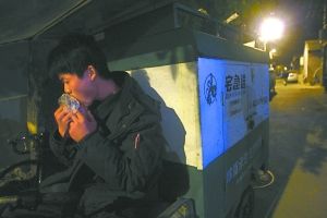 快遞哥抽空吃兩口東西。記者 李剛 攝