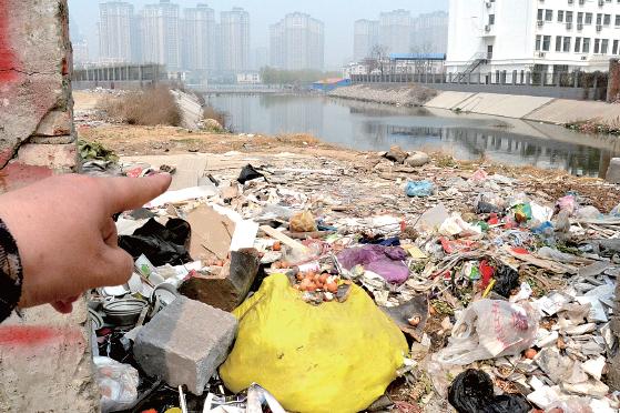 金水河長江路橋下河水發(fā)臭，水邊堆放眾多垃圾