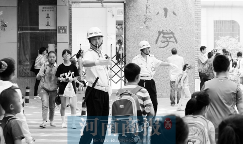 伊河路小學門口，兩名巡防隊員護送學生過馬路
