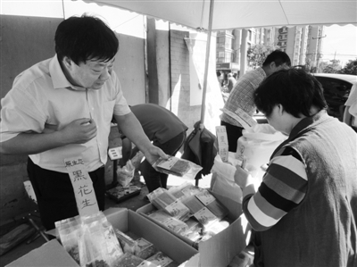 昨日，河南企業(yè)家劉春喜在京“練攤”，為顧客挑選綠豆。新京報(bào)記者 張玉學(xué) 攝