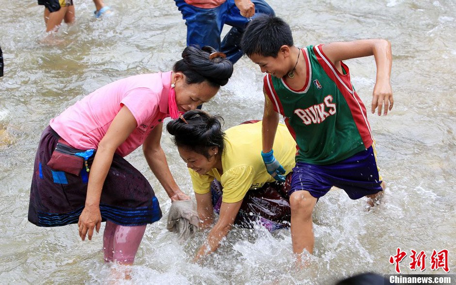 7月9日，村民在小河里摸魚(yú)搶魚(yú)。譚凱興 攝