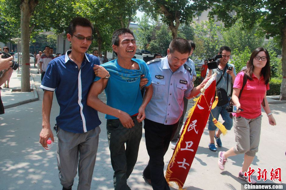 圖為獲救嬰兒父親情緒一度失控，當(dāng)?shù)鼐焦ぷ魅藛T對其進行攙扶。張一辰 攝