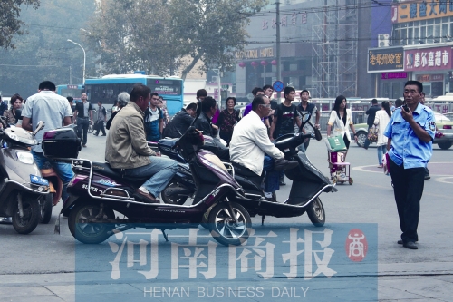 　火車站廣場北側(cè)，幾輛摩的正在等客