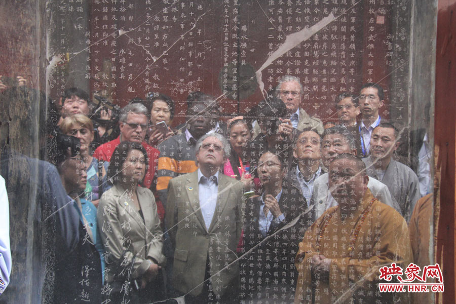 在一塊石碑前，少林寺方丈正在講解