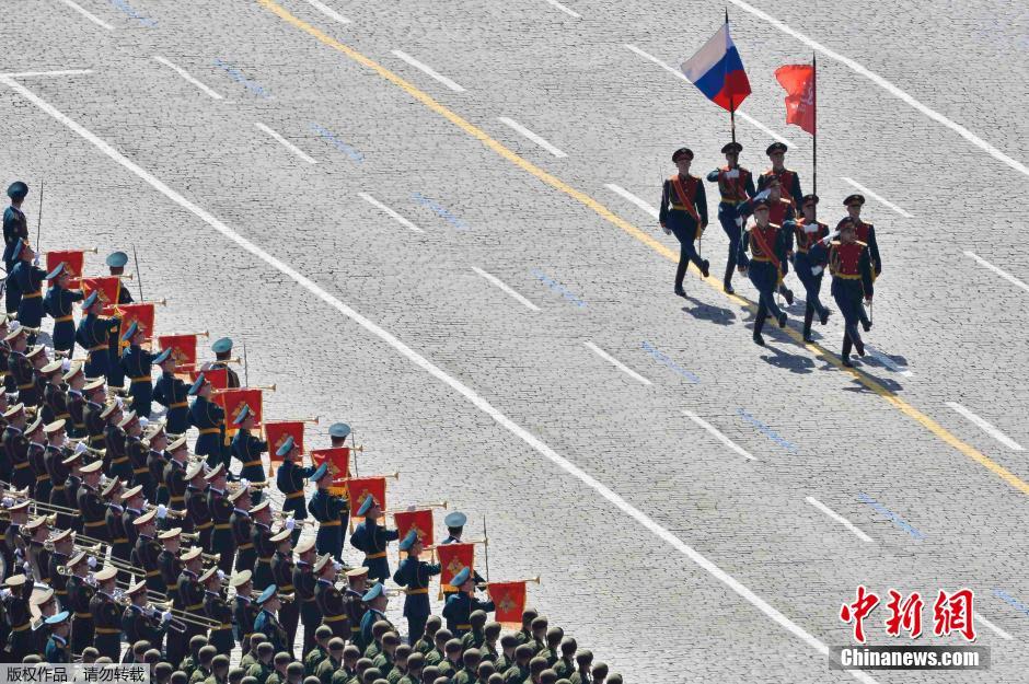 圖為俄羅斯國(guó)旗從受閱部隊(duì)前經(jīng)過。