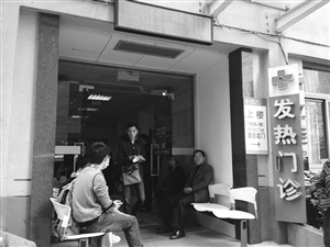 到浙大一院發(fā)熱門診就診的病人增多，不少人在門口等候