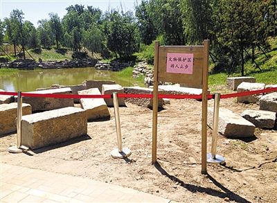 圓明園規(guī)月橋橋體構(gòu)件區(qū)域的警戒線和提示牌。 新京報記者 鄧琦 攝