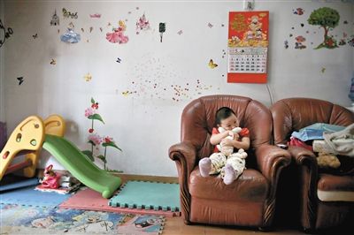 6月14日，未婚媽媽于軍的家里。女兒悅悅抱著兔子玩偶，在聽(tīng)媽媽手機(jī)上的兒歌，這個(gè)4歲女孩喜歡兔子。