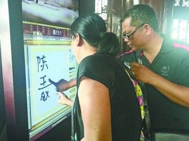 　圖為一對游客夫妻在“涂鴉”。