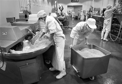 昨日，位于順義李遂開(kāi)發(fā)區(qū)的慶豐包子鋪配送中心生產(chǎn)車間，工人們正在斬拌胡蘿卜餡料。