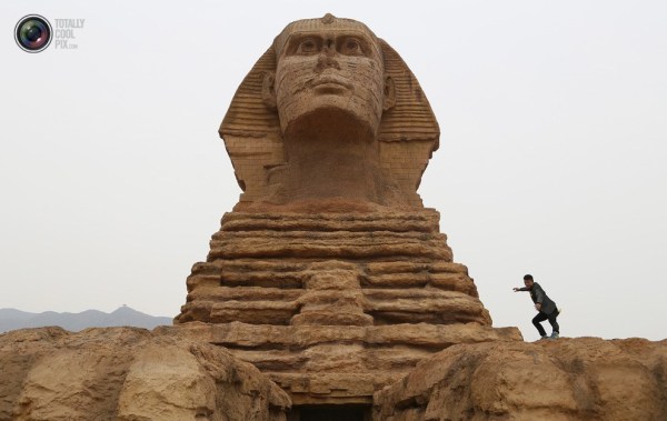 石家莊郊外，一名男子與山寨版獅身人面像合影留念。