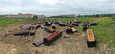 40多副棺木被砸壞后，扔在荒地上。