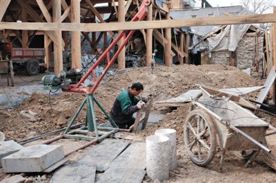 東城區(qū)北鑼鼓巷與小經(jīng)廠胡同之間一處四合院內(nèi)，工人進(jìn)入已經(jīng)挖好的地下室內(nèi)施工。