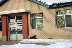 伊春市帶嶺區(qū)一排破舊的平房，房間窗戶上貼滿了“我告饒了”的字樣。