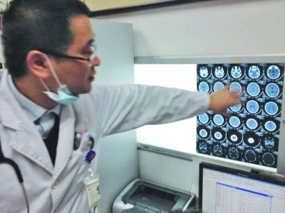 醫(yī)生在查看男孩的腦部CT片。薛馬義 攝