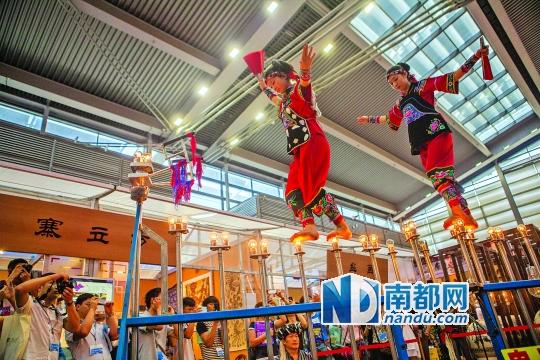 2號(hào)展館，苗族姑娘表演踩燈泡絕技《電光玫瑰》，赤腳踩上40瓦的燈泡并做出高難度動(dòng)作。 南都記者 霍健斌 攝