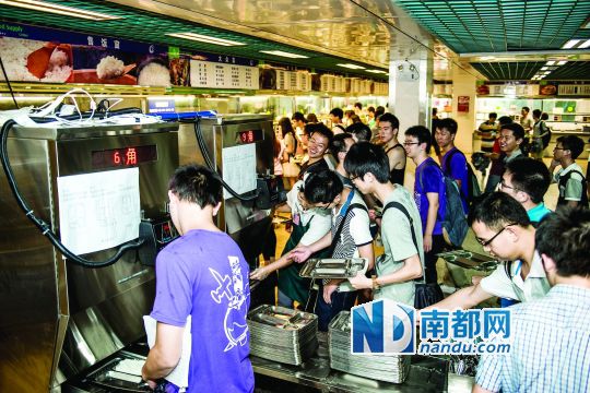 昨日，華南理工大學(xué)一食堂內(nèi)，學(xué)生們正在使用新安裝的自動(dòng)打飯機(jī)打飯。中新社發(fā)