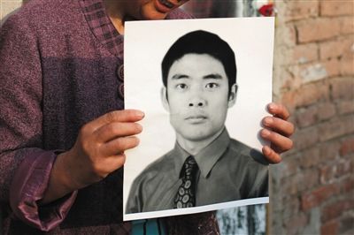 5月19日，朝陽(yáng)北路，母親捧著張東文的遺像。新京報(bào)記者 侯少卿 攝