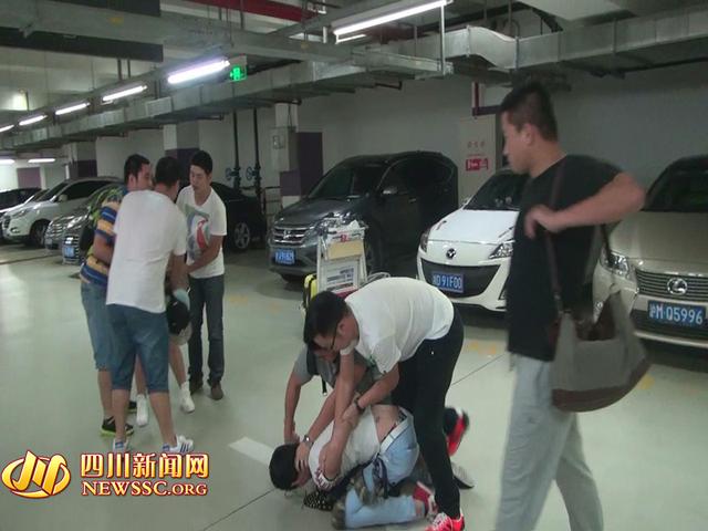 辦案人員在機(jī)場(chǎng)停車(chē)場(chǎng)抓獲胡某及其女友（警方視頻截圖）。