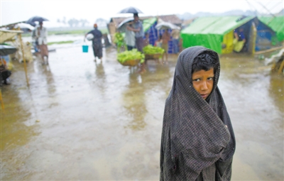 5月14日，緬甸若開邦實(shí)兌難民營，羅興亞族難民在雨中行走。熱帶風(fēng)暴“馬哈森”即將登陸緬甸，這里的難民開始乘船撤離。