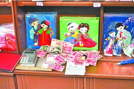 　　2012年6月21日，在朝鮮羅先特別市的一家商店里，柜臺上散落著一些人民幣。在朝鮮，人民幣比本國