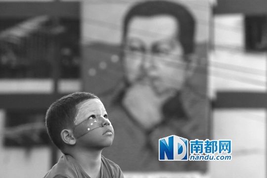 3月5日，一名委內(nèi)瑞拉兒童仰望天空，他身后是查韋斯的陵墓。