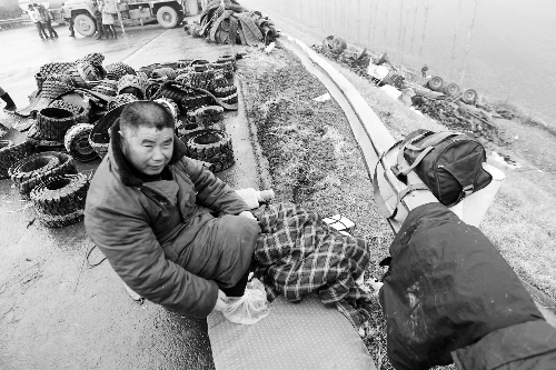 　出事司機(jī)的鞋找不到了，只好用塑料袋套著腳取暖