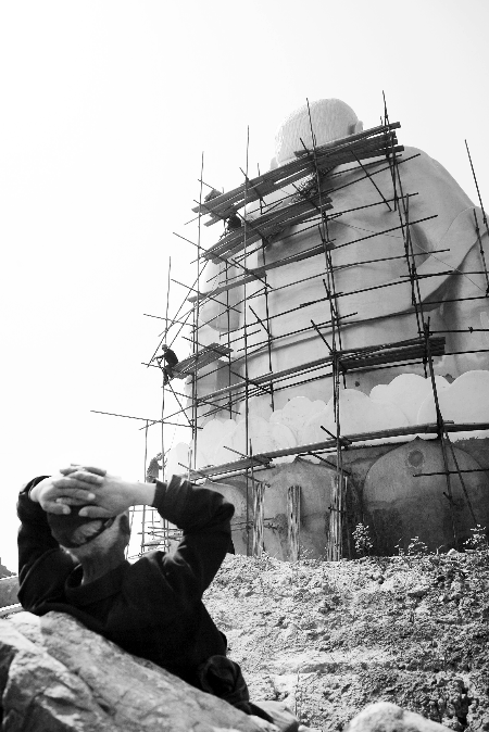 今年4月26日，工作人員將帆布蓋在“佛像”頭像上