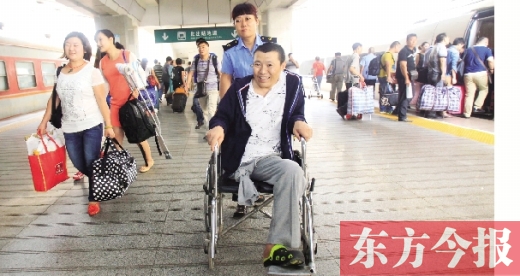 李剛手術(shù)后歸來(lái)，在車(chē)站工作人員幫助下走出鄭州火車(chē)站站臺(tái)  東方今報(bào)首席記者 張曉冬 攝