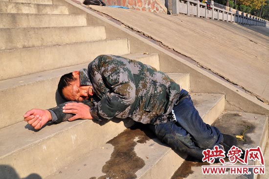 這名男子的衣服以及褲子全濕透了，水從衣褲里流出來，嘴里散發(fā)著濃烈的酒氣。