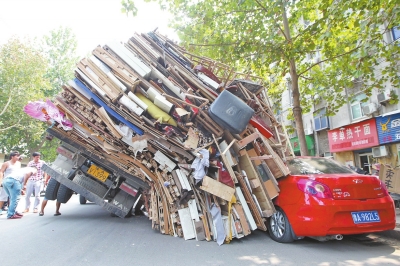 紅色小轎車被砸，卡在路邊動(dòng)彈不得。