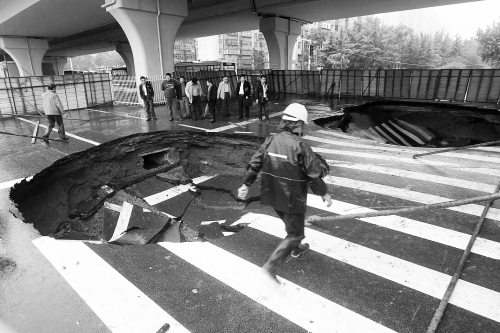中原路西三環(huán)立交橋下由南向北原本4個(gè)車道，由于塌坑，而今3個(gè)車道被圍擋