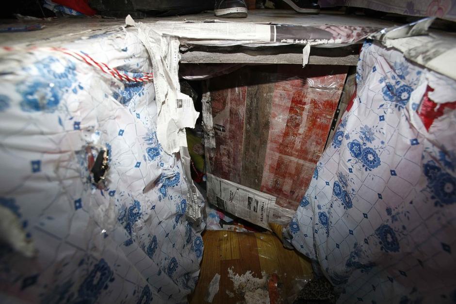 陳小龍在出租屋外，自行又圍起一堵圍墻，安裝了一個門。圍墻上都是豎起的鐵釘，外面堆著土，鄰居猜是從地底挖出來的。洞口就在床邊，0.5米見方，深約1.5米。洞口表面一塊紙板掩蓋，打開紙板跳入洞底，是一扇小木門，木門外有插銷，可以從外面鎖上。