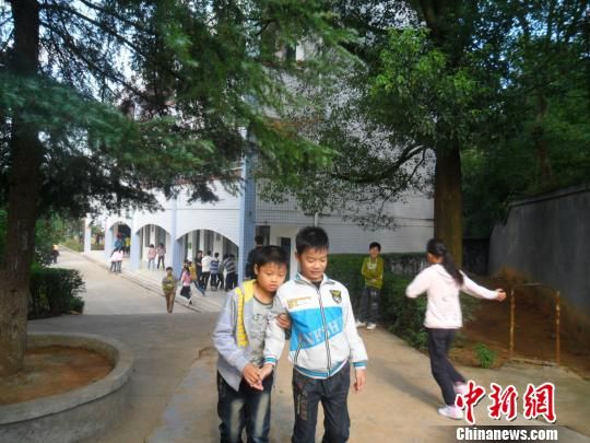 4年來，13歲的余興泉（左一）每天都攙扶著腿腳不便的同學(xué)左臣進(jìn)出教室、食堂和廁所。 李俊杰 攝