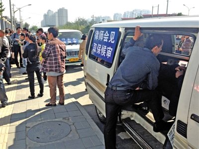 昨日，朝陽區(qū)看守所門前有人排隊。大門外還停有多輛寫有“律師會見”字樣的車。