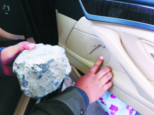 “飛”進(jìn)寶馬車內(nèi)的大石塊,將寶馬車的車門內(nèi)飾板砸爛。