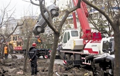 輸油管道爆炸后，搶修人員將被炸毀的車輛運(yùn)出現(xiàn)場。