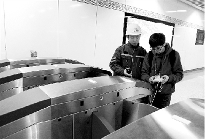 昨天上午，體育中心站，工作人員正在對進出站閘機進行調(diào)試。