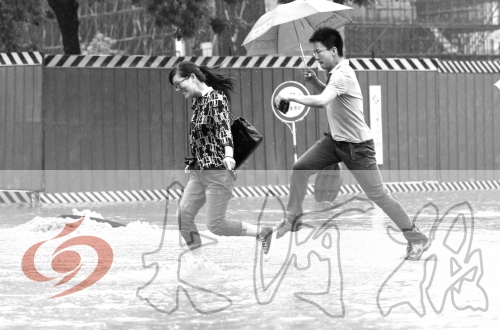 鄭州經(jīng)三路與北環(huán)交叉口處，積水較深，行人們不得不“練輕功”。 記者 白周峰 攝影