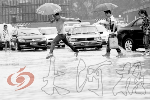 鄭州經(jīng)三路與北環(huán)交叉口處，積水較深，行人們不得不“練輕功”。 記者 白周峰 攝影