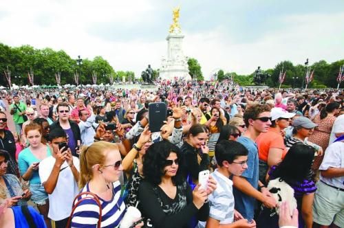 7月23日，在英國(guó)倫敦白金漢宮外，民眾們爭(zhēng)相閱讀“王室寶寶”出生的正式公告。