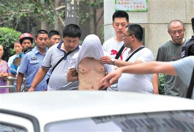 昨日，成都警方抓捕時與毒犯發(fā)生槍戰(zhàn)。一名男犯罪嫌疑人被警方押出。