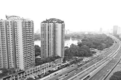 昨日，人濟山莊小區(qū)，與其他樓相比，B棟樓頂層天臺上違規(guī)建造了一棟兩層小樓，假山大樹俱全。新京報記者