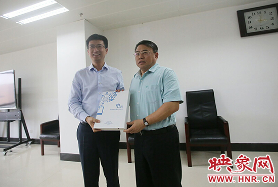 阿里云計(jì)算總裁胡曉明向河南省新聞出版廣電局局長朱夏炎遞交《中原云平臺(tái)交付手冊》。