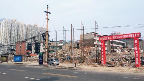 015年5月31日，在社區(qū)干部的帶頭拆遷下，親賢社區(qū)的“城中村改造”拉開帷幕。由于前期“清產(chǎn)核資”及補償標準等因素，拆遷改造工作推進并不順利。圖為位于體育西路東側集體所有的商鋪率先被拆遷完畢，用于遮擋的圍擋正在施工中。（拍攝：2015年9月16日）