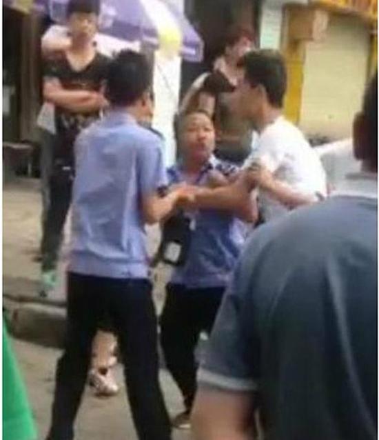 付某（右）與城管執(zhí)法人員廝打在一起。