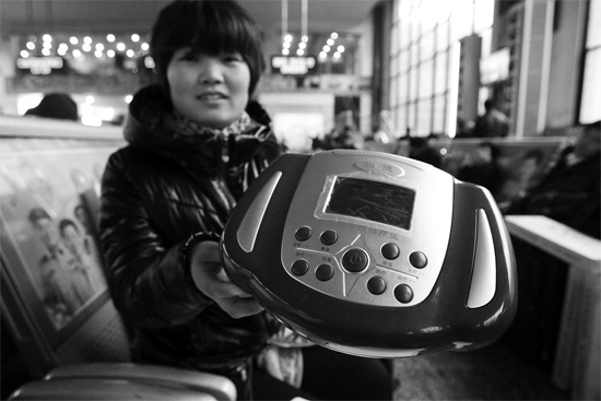 火車站候車室，李女士向記者展示她準(zhǔn)備孝敬父母的按摩儀